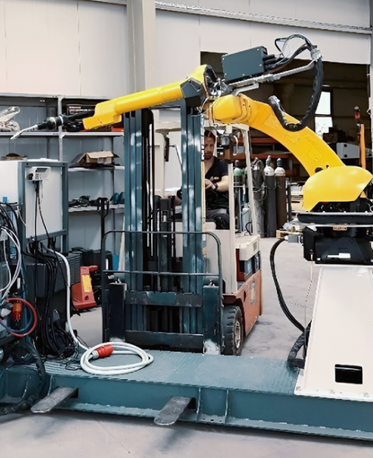 Two-workstation robotic welding cell for beach chair production